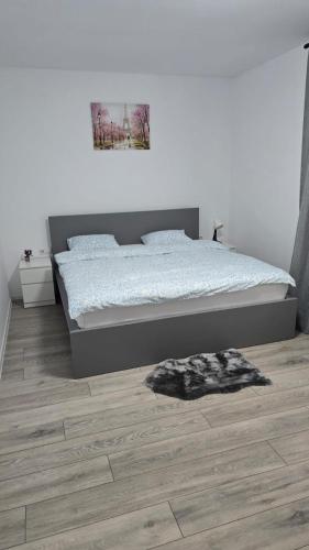 a bedroom with a bed and a wooden floor at Casa Magurele 3 in Măgurele