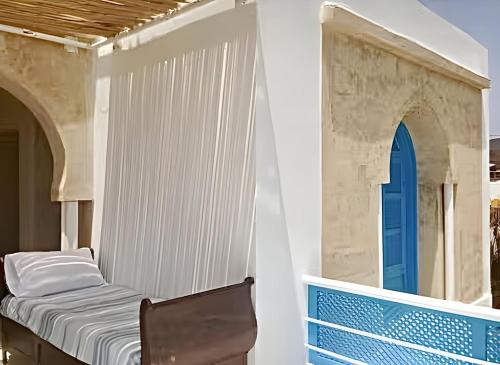 a bedroom with a bed and a blue door at Peaceful Haven, Villa Private Rooms, Absolute Quiet in Bin Rhilouf