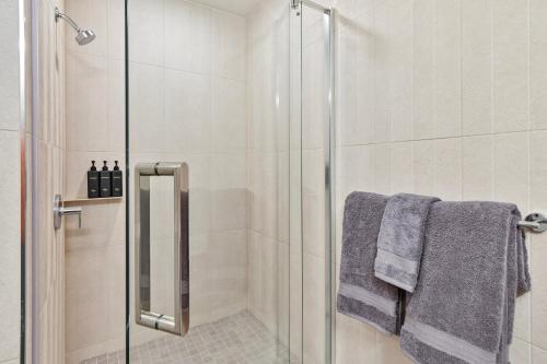 a bathroom with a shower with gray towels at Lux Sleeps 4 king bed hot tub views gym in Cranmer