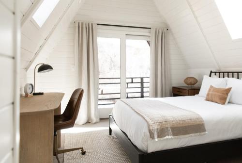 Un dormitorio con una cama y un escritorio y una ventana. en A-Frame Haus Heber views romantic firepit cute, en Timber Lakes