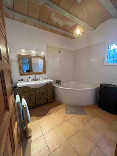 a large bathroom with a tub and a sink at Chalet en la naturaleza in Macastre