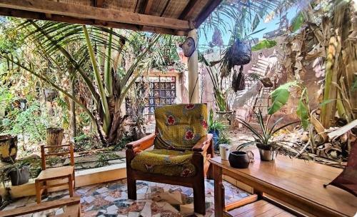 una habitación con una silla y una mesa con plantas en Mango House, en Saly Portudal