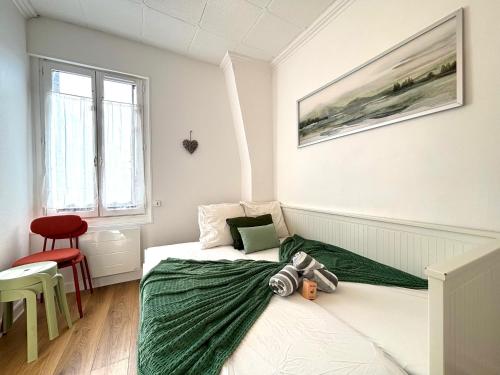 ein Schlafzimmer mit einem Bett mit einer grünen Decke darauf in der Unterkunft Primavera : Beau 2-pièces proche Paris, RER B 450m in Gentilly
