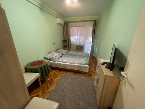 a small room with a bed and a television at Balaton-Lak Apartmanház in Siófok
