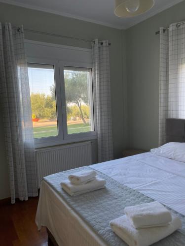 a bedroom with a bed and a window with towels on it at Solivia in Koropíon