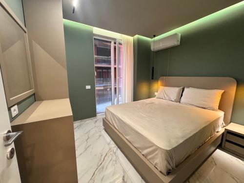 a bedroom with a bed and a green wall at Sunset Luxury Apartment Shengjin in Lezhë