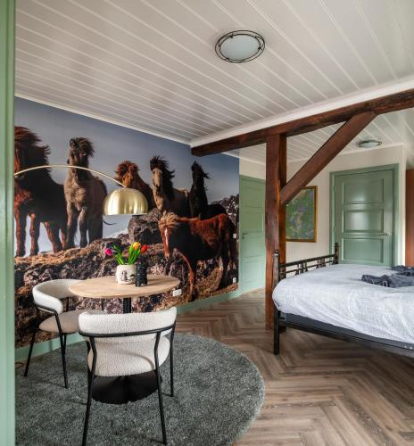 a bedroom with a bed and a table at Bed and Breakfast de Hoge Enk in Hierden
