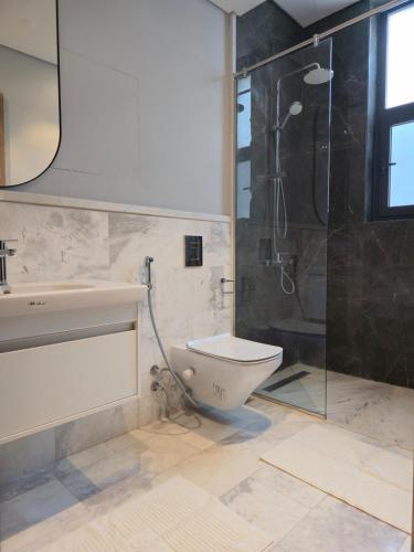 a bathroom with a toilet and a glass shower at The view in Banī Ghālib