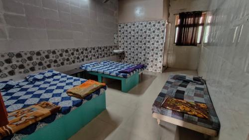 Habitación con 2 camas y 2 mesas. en DYO Agrasan Bhavan, en Dwarka
