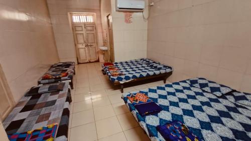 una habitación con tres camas en una habitación en DYO Agrasan Bhavan, en Dwarka