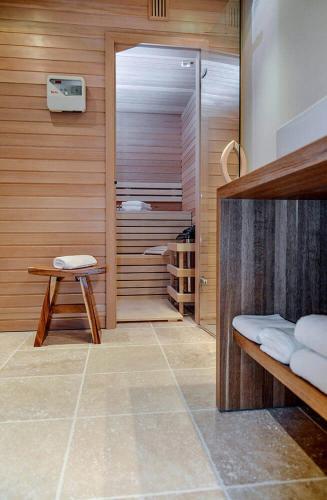 a room with a sauna with a bench and a stool at Endless Summer mit Sauna, Hörnum, Sylt - 1 Hund willkommen in Hörnum