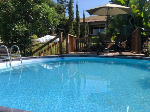 una grande piscina blu con ombrellone di Casa de campo María Isabel a Montitlán