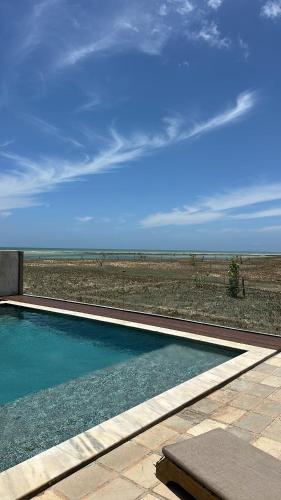 a swimming pool with a view of the desert at Caly Pousada in São Miguel do Gostoso