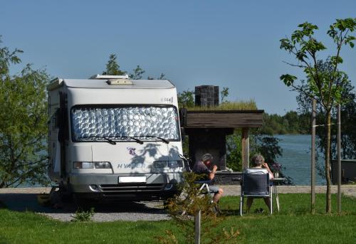 a white truck parked in a yard with two people at Zagreb Camp Bungalows in Rakitje