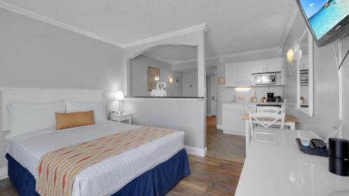 a hotel room with a bed and a kitchen at Pelican Pointe Clearwater Beach Hotel in Clearwater Beach