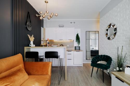cocina y sala de estar con sofá y sillas en Baltic 4YOU 3, en Pobierowo