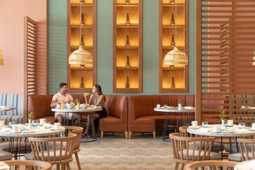 Un hombre y una mujer sentados en mesas en un restaurante. en Steigenberger Resort Ras Soma, en Hurghada