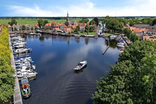 un groupe de bateaux est amarré dans une rivière dans l'établissement In de Kathoek - Beste voorwaarden via eigen kanaal, à Blokzijl