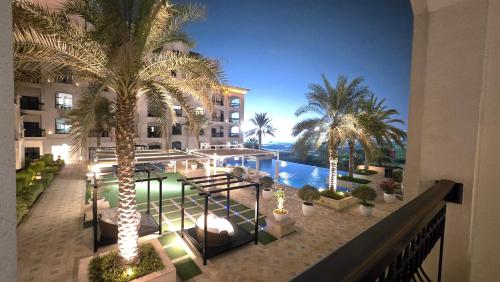 an aerial view of a hotel with a pool and palm trees at F1 - Ivy Studio Golf View Ansam Yas Island, Theme Parks in Abu Dhabi