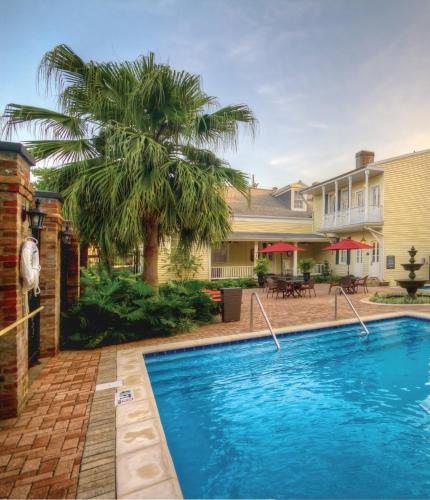 a swimming pool in front of a house with a palm tree at Club Wyndham Avenue Plaza in New Orleans