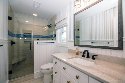 a bathroom with a toilet and a sink and a mirror at A Shore Investment in Edisto Island