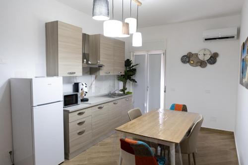 a kitchen with a table and a white refrigerator at Adagos in Palermo