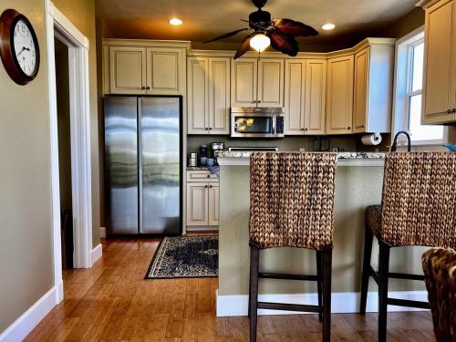 una cucina con mobili bianchi e un frigorifero di Tipsy Turtle a Captiva