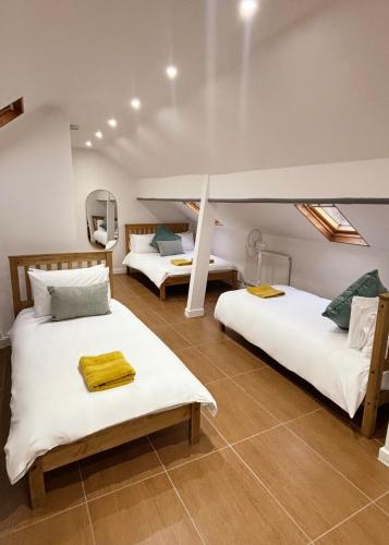 a room with two beds in a room at Welsh Getaway Studio Loft in Merthyr Tydfil