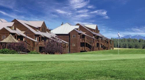 a large building on a golf course with a green at Club Wyndham Pagosa in Pagosa Springs