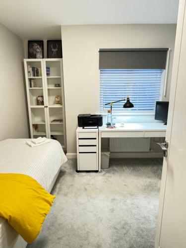 ベティーズタウンにあるCozy Coastal Home Bettystownのベッドと机と窓のある寝室