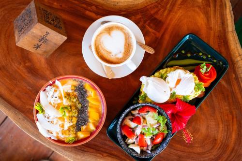 a table with two plates of food and a cup of coffee at Hostel 197 in Nungwi
