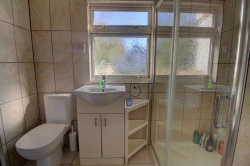 a bathroom with a toilet and a sink and a shower at 3 Bed House in Reading Area in Reading
