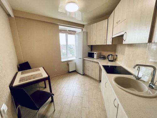 Квартири подобово центр في دنيبروبيتروفسك: مطبخ صغير مع حوض وطاولة