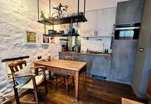 a kitchen with a wooden table and a refrigerator at Posh Studio Apartment Heart of Newlyn in Newlyn