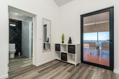 ein Wohnzimmer mit einer Tür zum Esszimmer in der Unterkunft Casa do Paulinhos in Estreito da Calheta