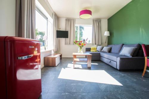 a living room with a couch and a refrigerator at Landgoed Leudal - In de natuur nabij Roermond in Haelen