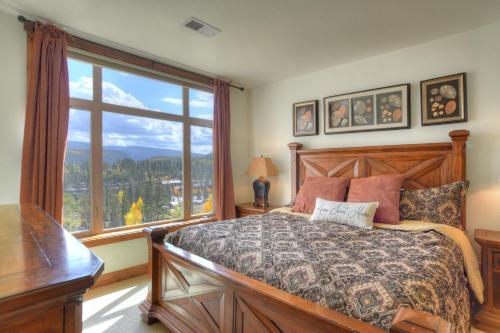 a bedroom with a bed and a large window at Peregrine Point 106 in Durango Mountain Resort