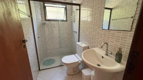 a bathroom with a toilet and a sink and a shower at Surf House Mar Brasil in Ubatuba