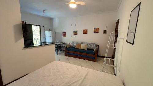 a living room with a couch and a kitchen at Surf House Mar Brasil in Ubatuba