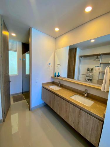 a bathroom with two sinks and a large mirror at Reserva del Mar in Puerto de Gaira
