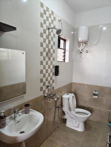 a bathroom with a sink and a toilet and a mirror at Casa River View in Dabolim