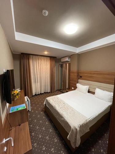 a hotel room with a bed and a flat screen tv at Pensiunea Crystal in Iaşi
