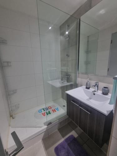 a white bathroom with a sink and a shower at Se Arrienda Hermoso Departamento con vista al mar in Viña del Mar