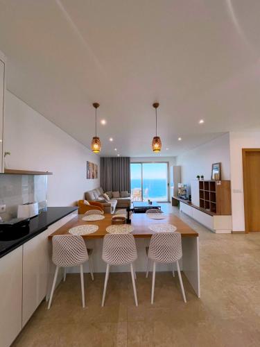 a kitchen and living room with a table and chairs at Holiday House Caetano in Ponta do Sol
