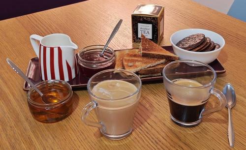 a tray of food with two glasses of coffee and toast at LGBTQ-Double room in London