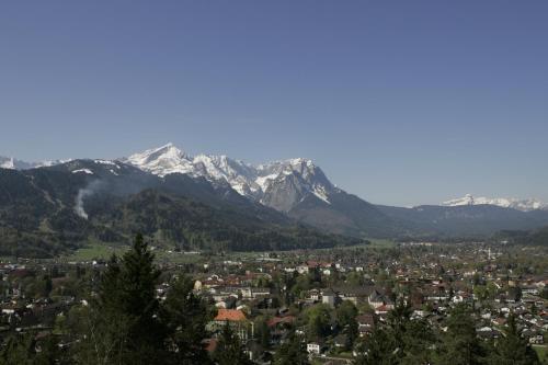 a city with snow capped mountains in the background at Landkomforthotel Panorama & Restaurant Bella Vista in Garmisch-Partenkirchen
