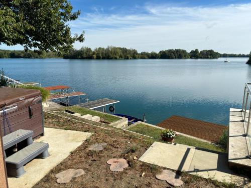 a view of a lake with a bench and a dock at Niki Tóparti Pihenő in Gyékényes