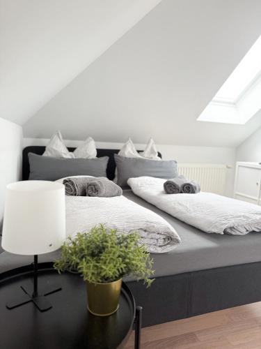 two beds in a room with a table with a lamp at Wattwürmchen in Wremen