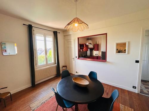 a dining room with a table and chairs and a mirror at 6 benoit in Reims
