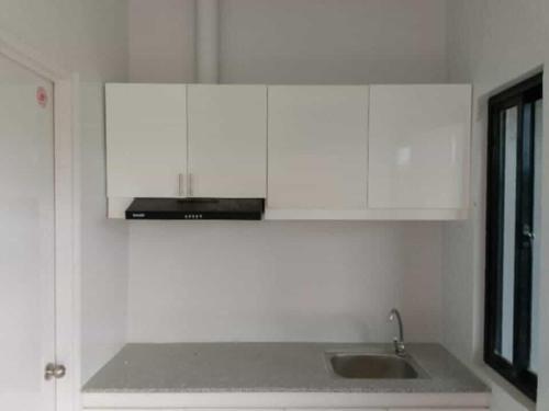 eine Küche mit Spüle und weißen Schränken in der Unterkunft M&S Cabina in Alburquerque
